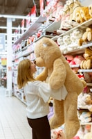 woman carrying life size bear plush toy