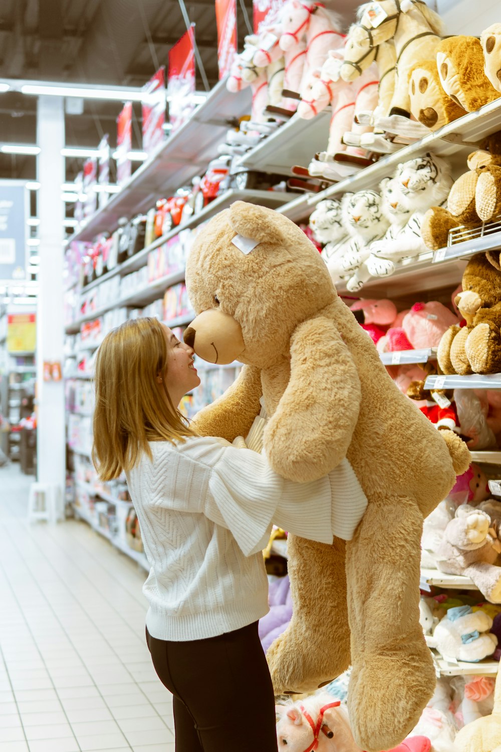 woman carrying life size bear plush toy