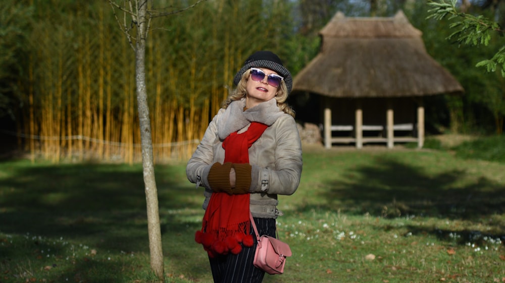 woman in gray jacket standing near trees