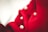 Rich red fabric features several large, glossy white pearls embedded within its softly draped surface, creating a luxurious and elegant texture.
