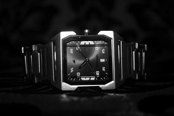 Modern minimalist watch face with bold hour markers on a dark surface.