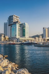 white and green building beside body of water under blue sky
