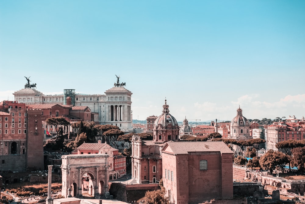 fotografia aerea di edifici in cemento marrone e bianco sotto il cielo blu durante il giorno