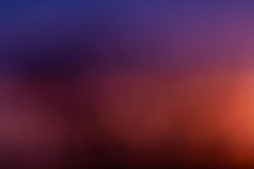 A blurred, colorful gradient blending softly into a dark void.