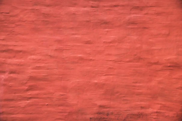 Close-up of artisan painting a textured wall with warm, inviting colors