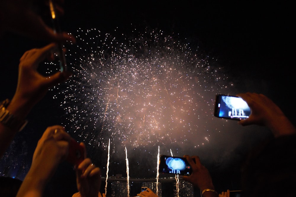 people taking photo of fireworks