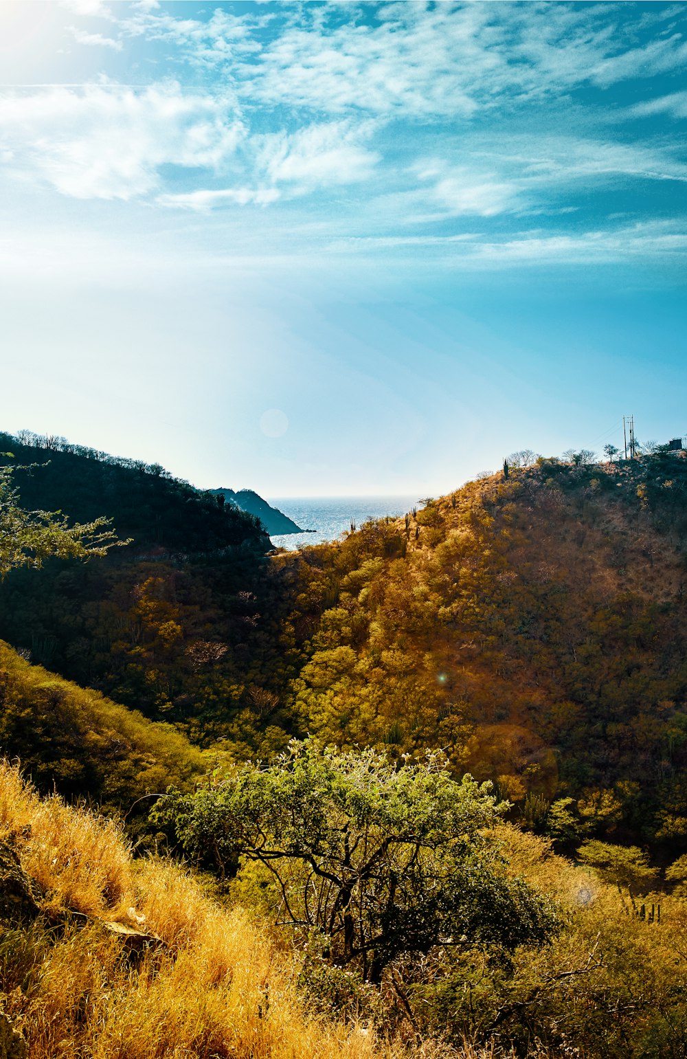 view of mountain under blue sky and ocean