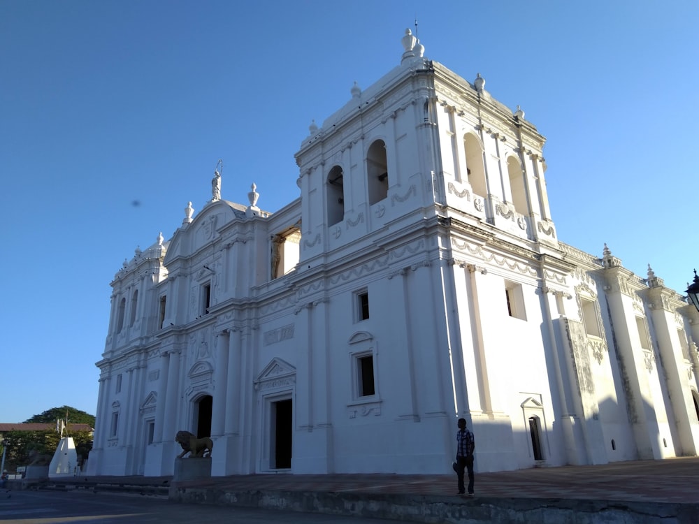 man standing near white building under blue sky