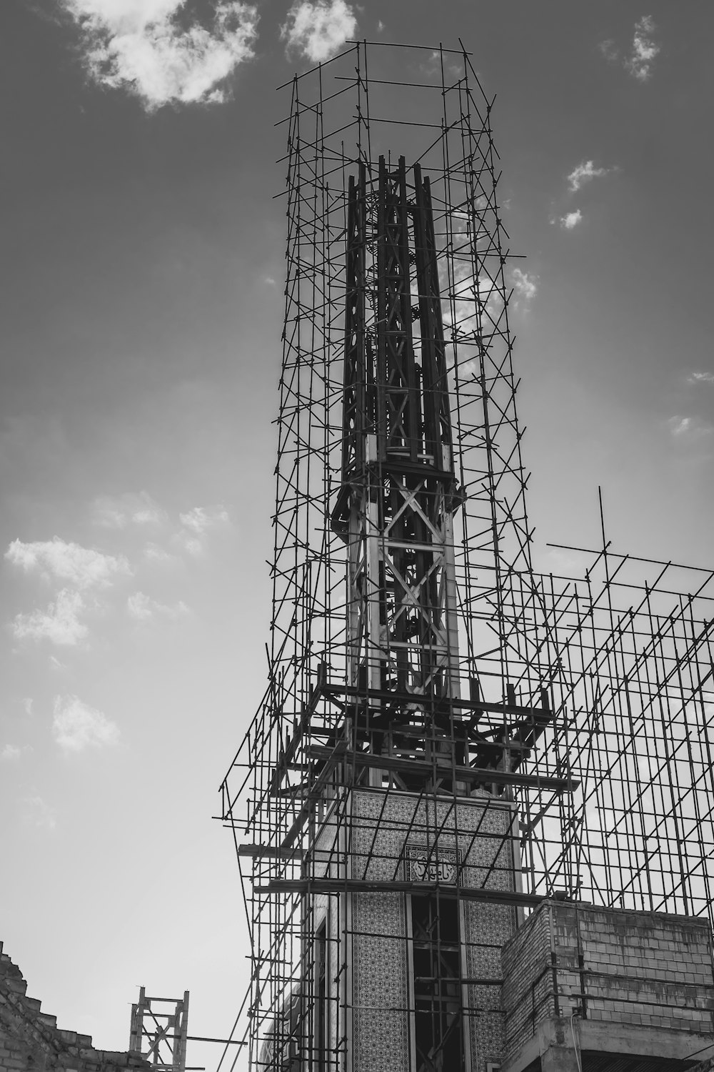 grayscale photography of scaffolding surrounding building