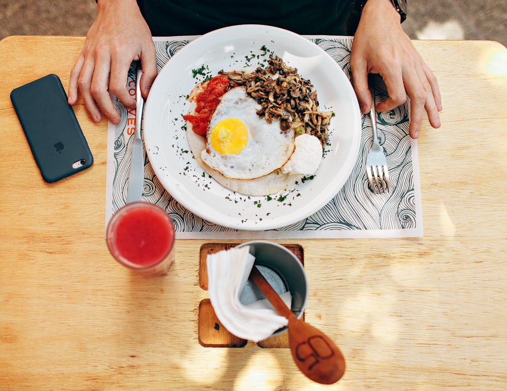 person touching spoon and fork