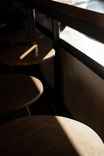 A cozy kitchen corner with a sturdy industrial metal bar stool beside a wooden countertop bathed in warm sunlight.