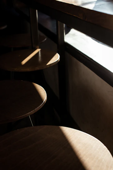 A cozy kitchen corner with a sturdy industrial metal bar stool beside a wooden countertop bathed in warm sunlight.