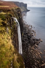 Film production services: waterfalls cascading into a calm sea during the daytime