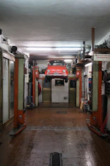 A shiny car undergoing a full oil change service on a lift.