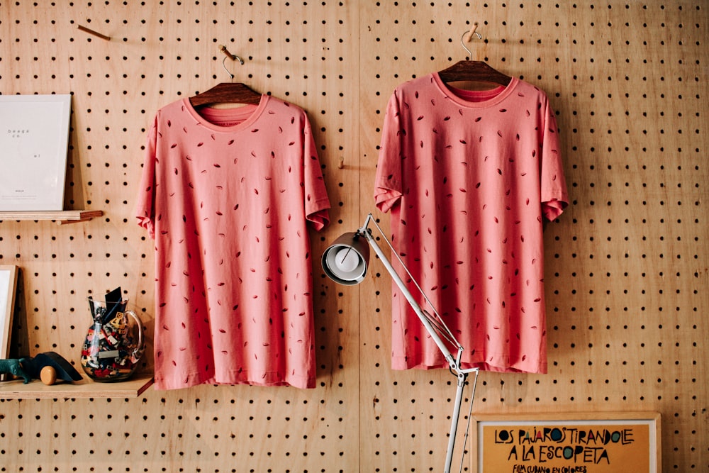 two red-and-black foliage crew-neck T-shirts hanging on hanger