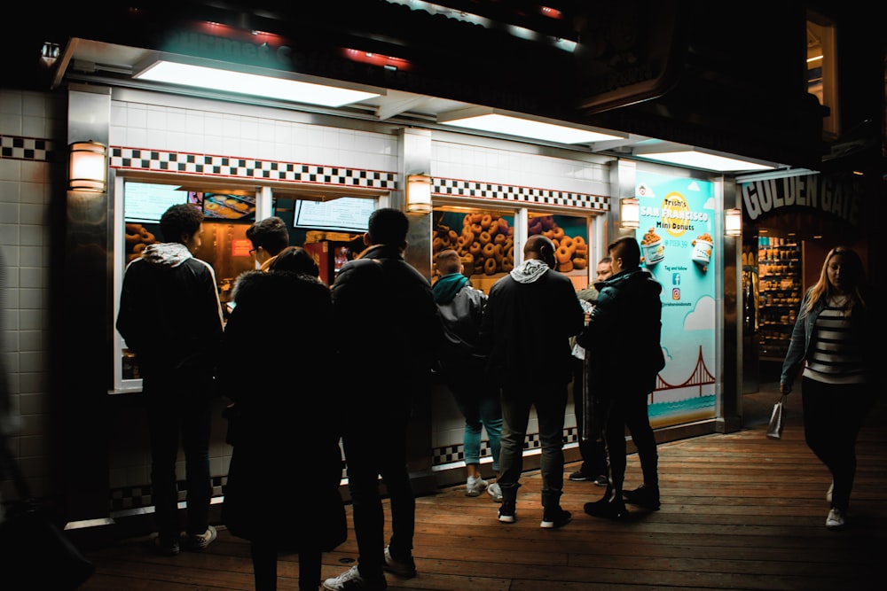 group of people standing beside food kart