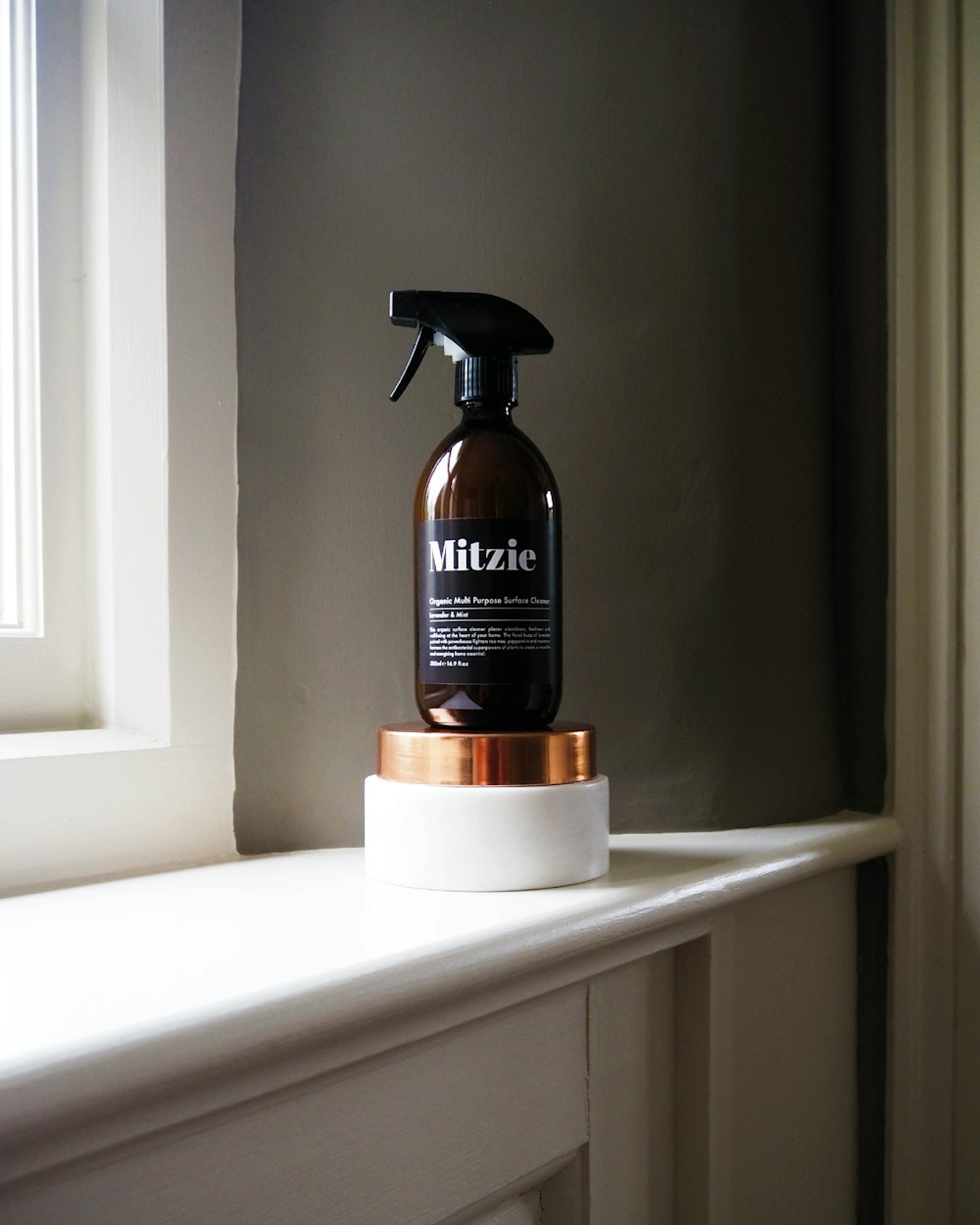 black Mitzie spray bottle near window