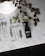 Close-up of a hand holding a sleek Verde Vitale cr videy spray bottle with fresh herbs in the background.
