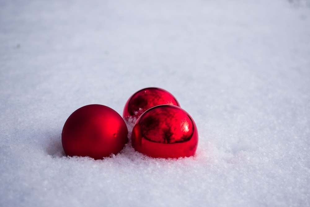 three red baubles on snow