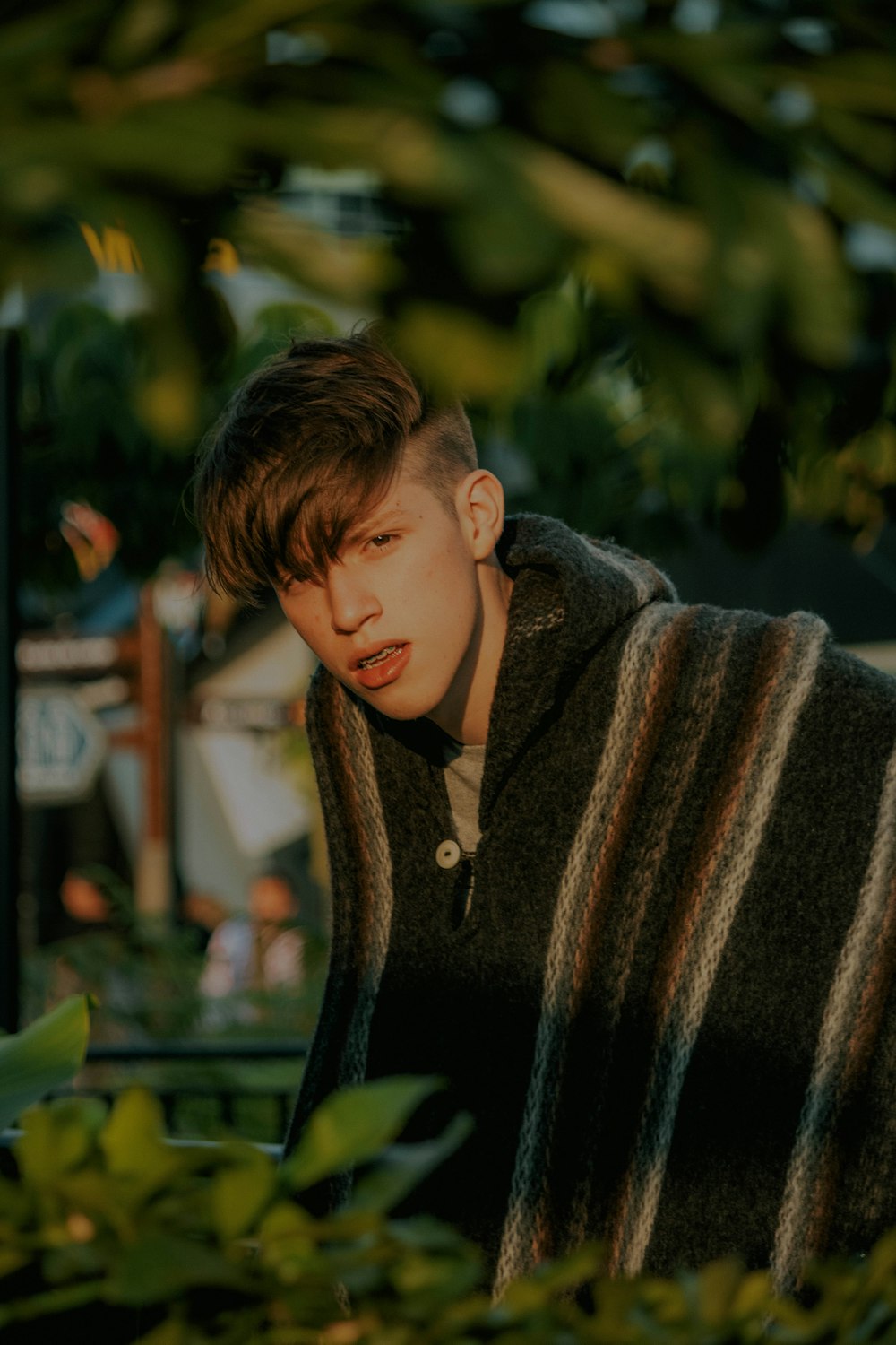 man in green coat under green trees