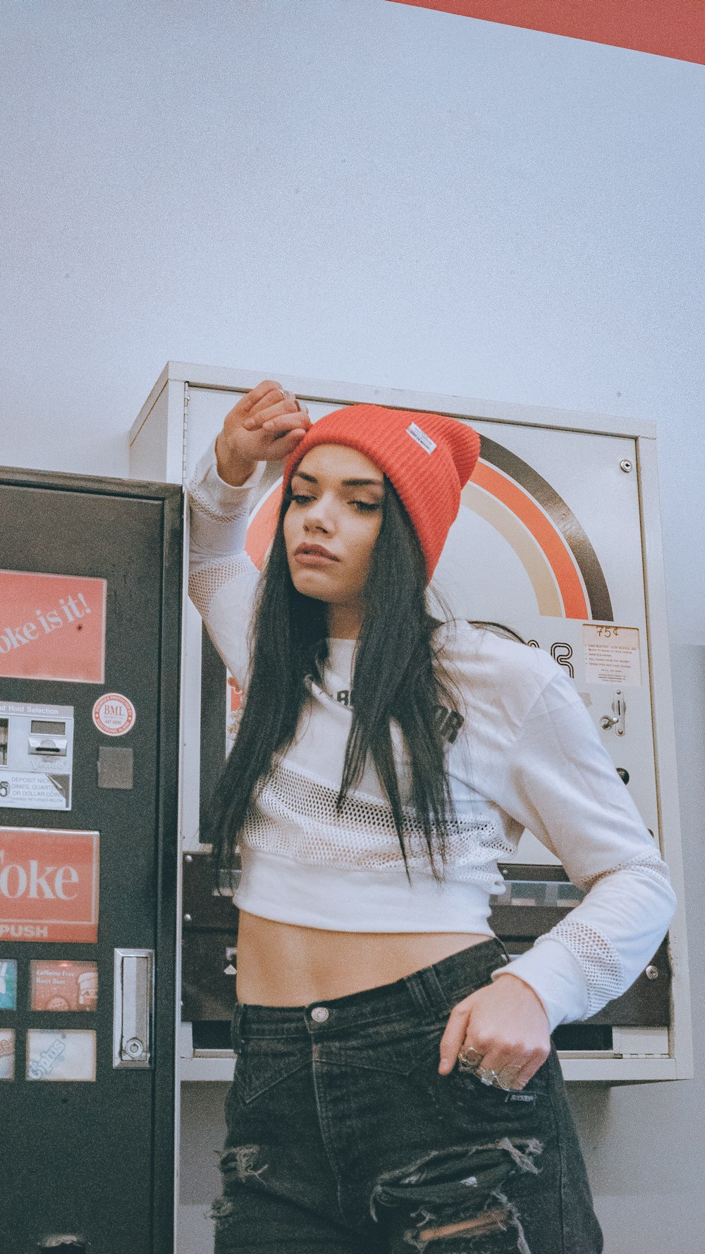 woman in white crop top leaning on metal cabinet