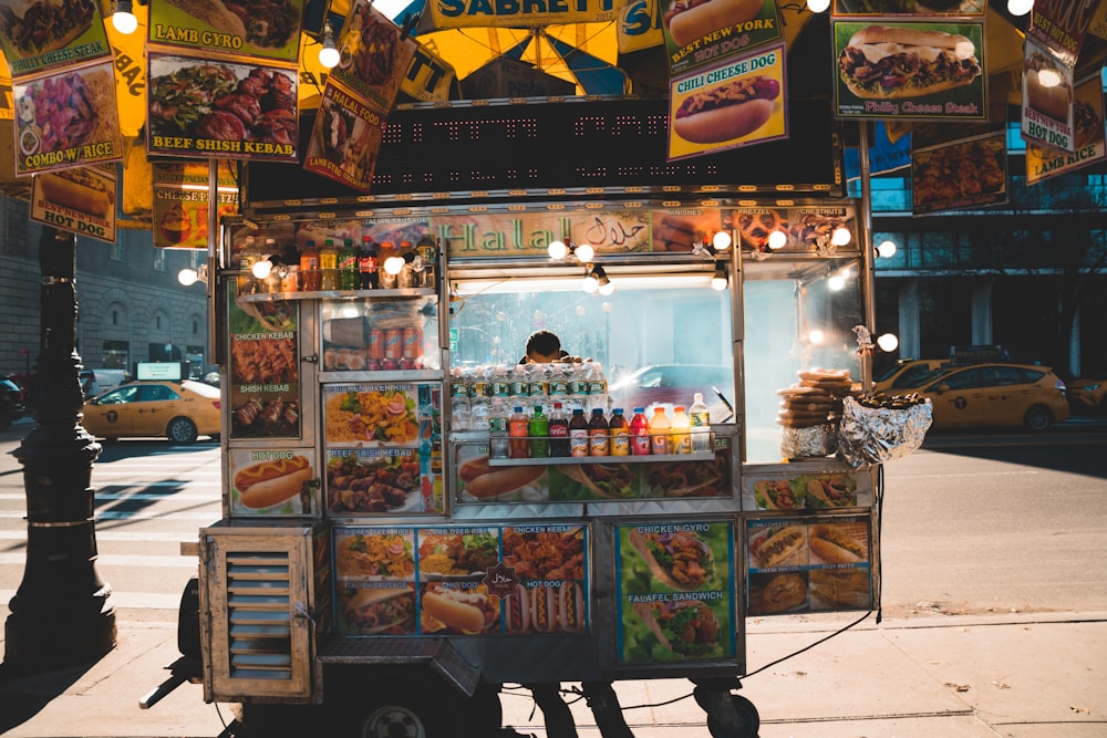 Persona de pie detrás del carrito de comida durante la noche