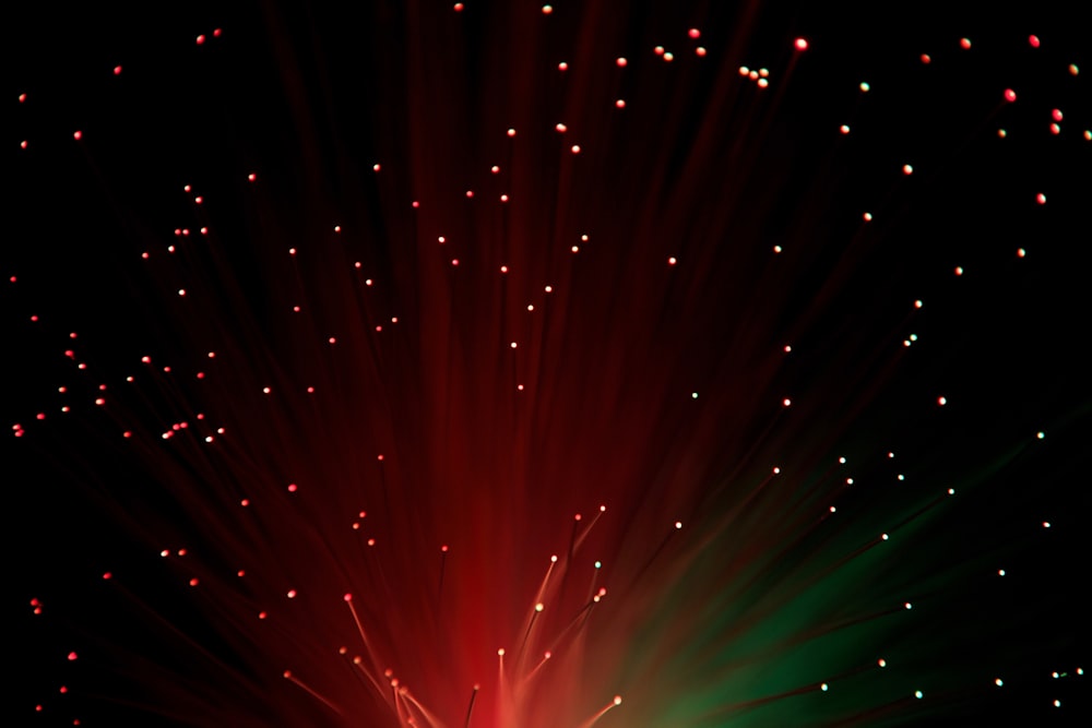 a red and green firework in the night sky