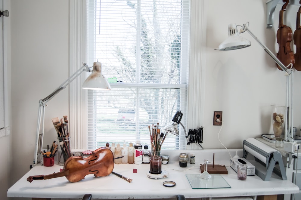 brown violin beside white desk lamp on table