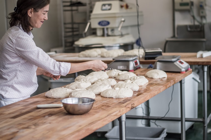 Baker at a wooden work table, photo by Maranda Vandergriff on Unsplash