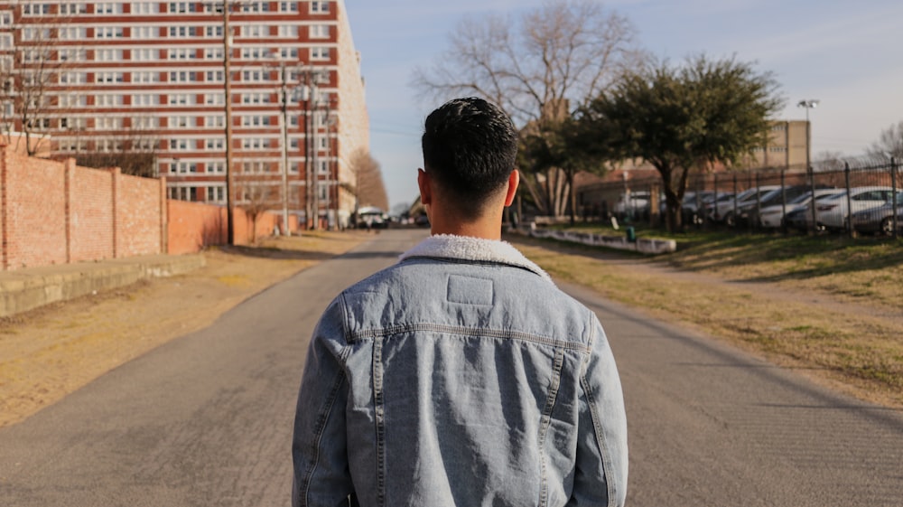 man standing in gray pathway near buildings