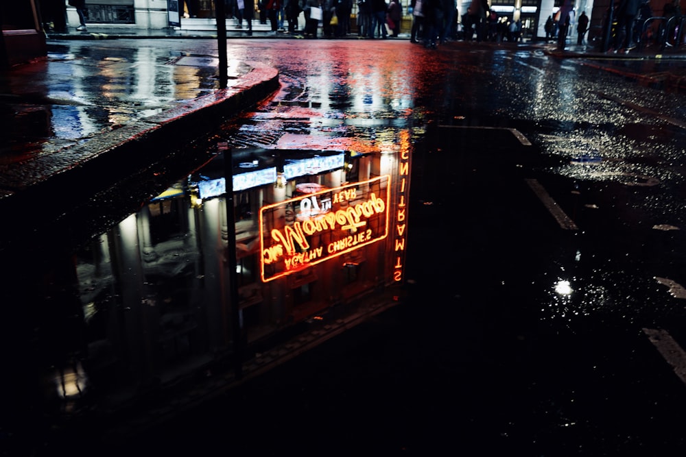 water with reflection of yellow signage