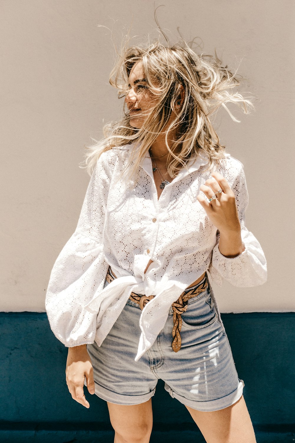 Mujer con camisa de vestir blanca y pantalones cortos de mezclilla azul