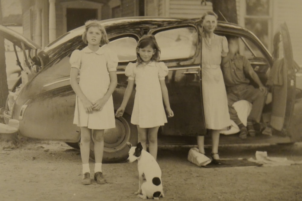 two girls and man and woman near house