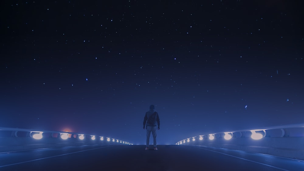 man standing at middle of bridge