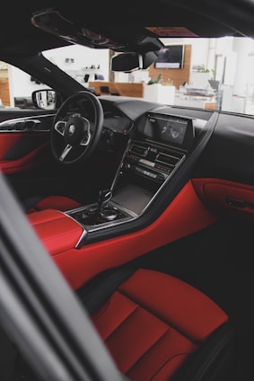 A sleek car interior showcasing premium sound system components with red and black accents.