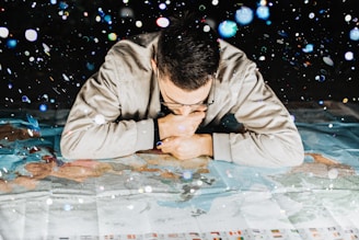 man in grey jacket leaning forward on map