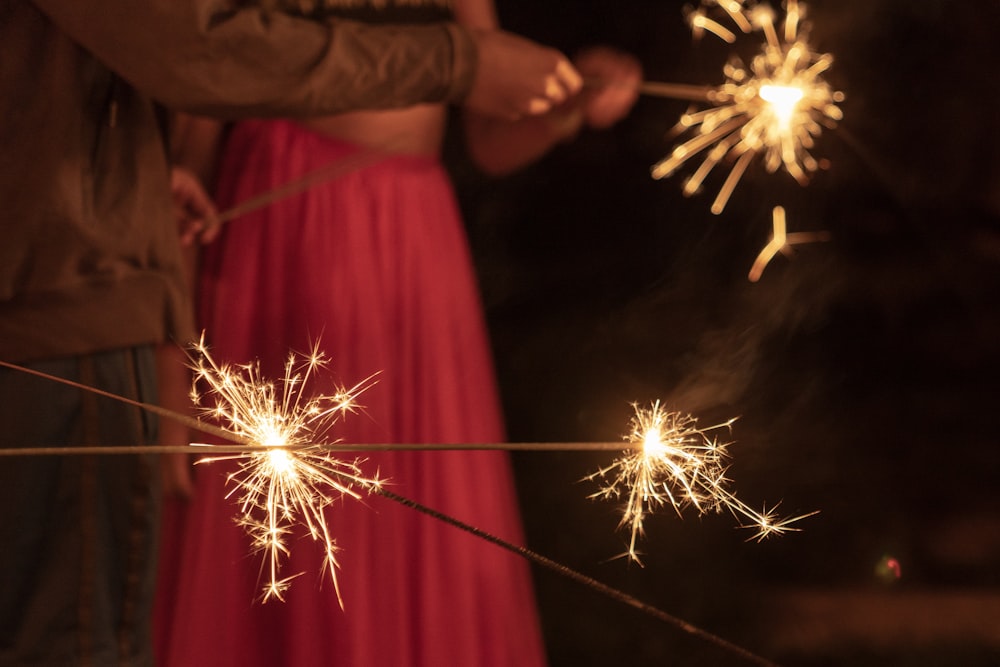 man and woman holding sparklers