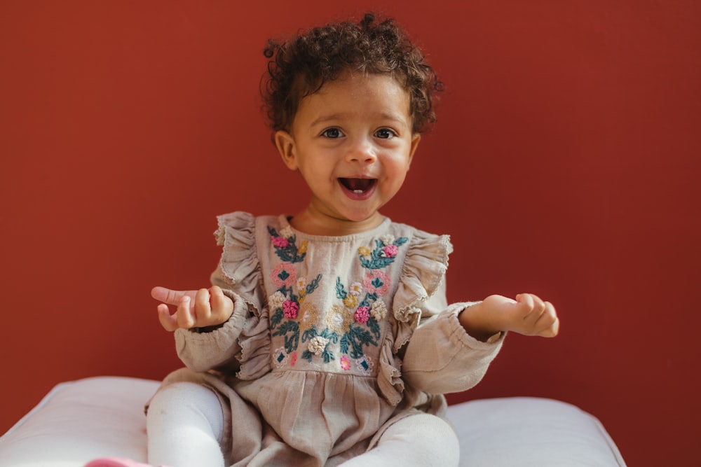 bébé fille portant une robe grise et des chaussettes blanches