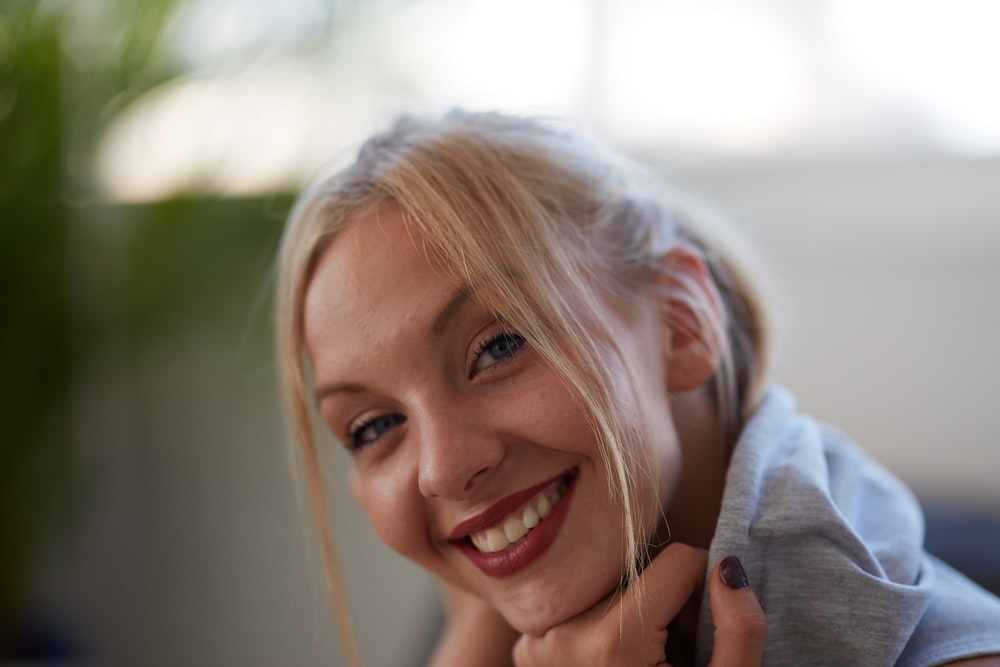 smiling woman in grey hoodie with red lipstick