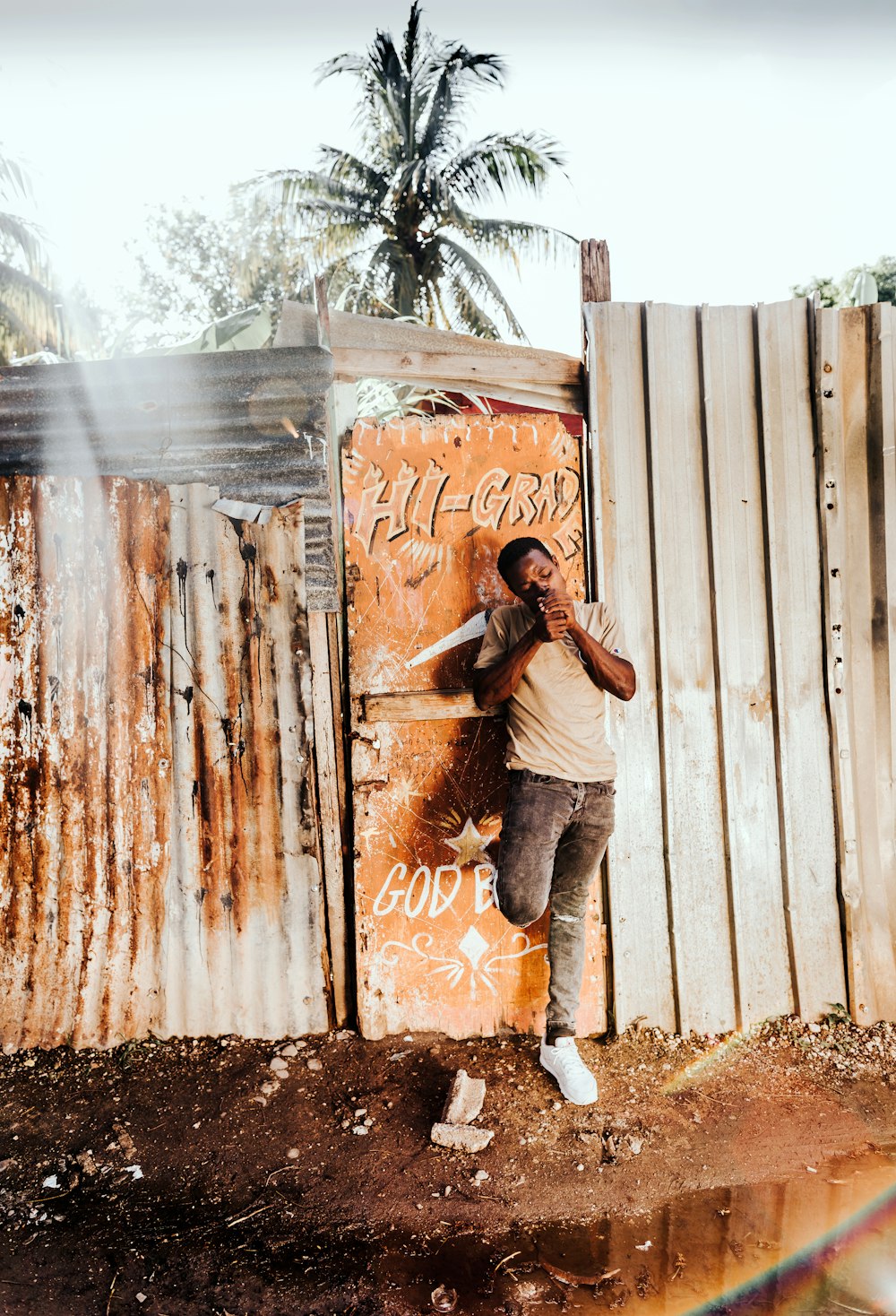 man standing beside gate