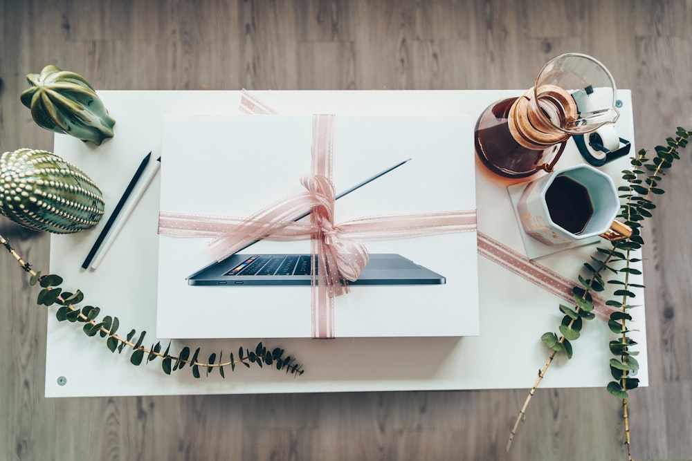 laptop box near mug with black coffee on table