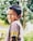 A happy child wearing a colorful t-shirt and carrying a backpack.