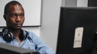 A focused support specialist troubleshooting a computer issue with headset on.