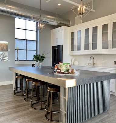 gray metal island table near white wooden kitchen cabinet