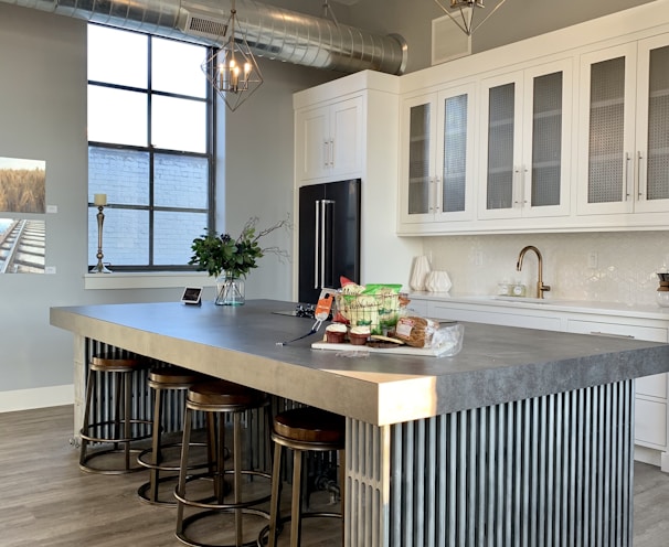 gray metal island table near white wooden kitchen cabinet