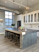 gray metal island table near white wooden kitchen cabinet
