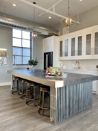 gray metal island table near white wooden kitchen cabinet