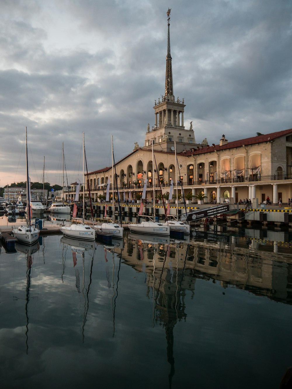 four white sailboats docked near white building