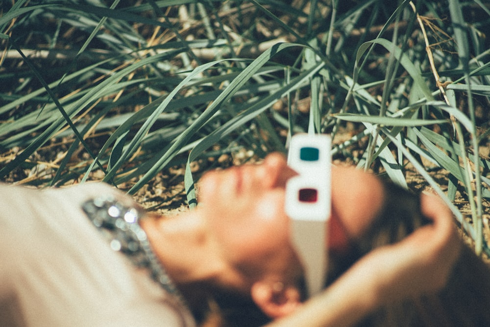 person using 3D glasses lying on grass