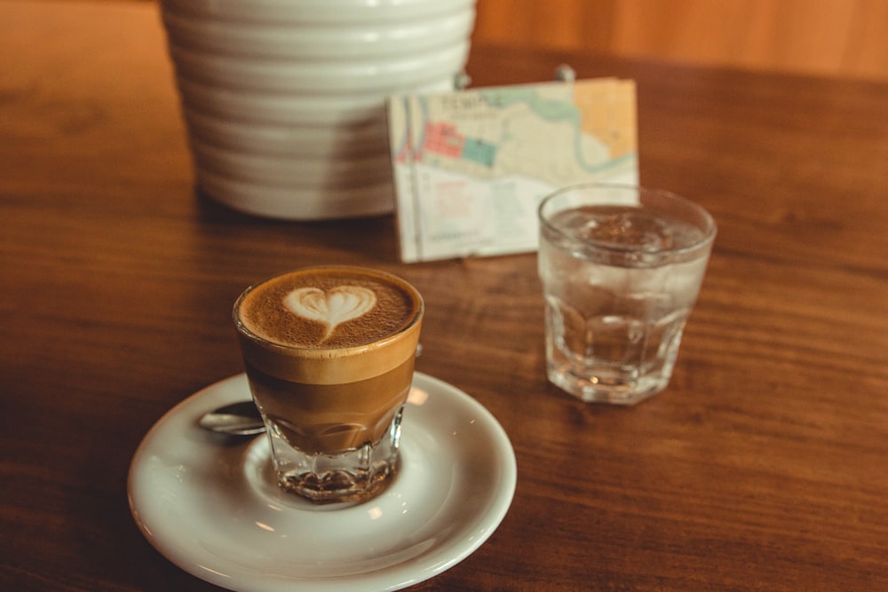 selective focus photography of drinking glass filled with coffee on top of table